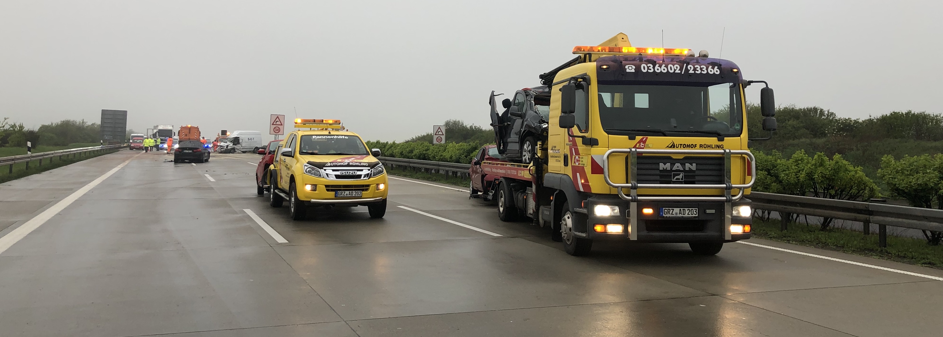 Zwei Abschleppwagen des Autohofs stehen auf der Autobahn an einer Unfallstelle und haben demolierte Autos aufgeladen